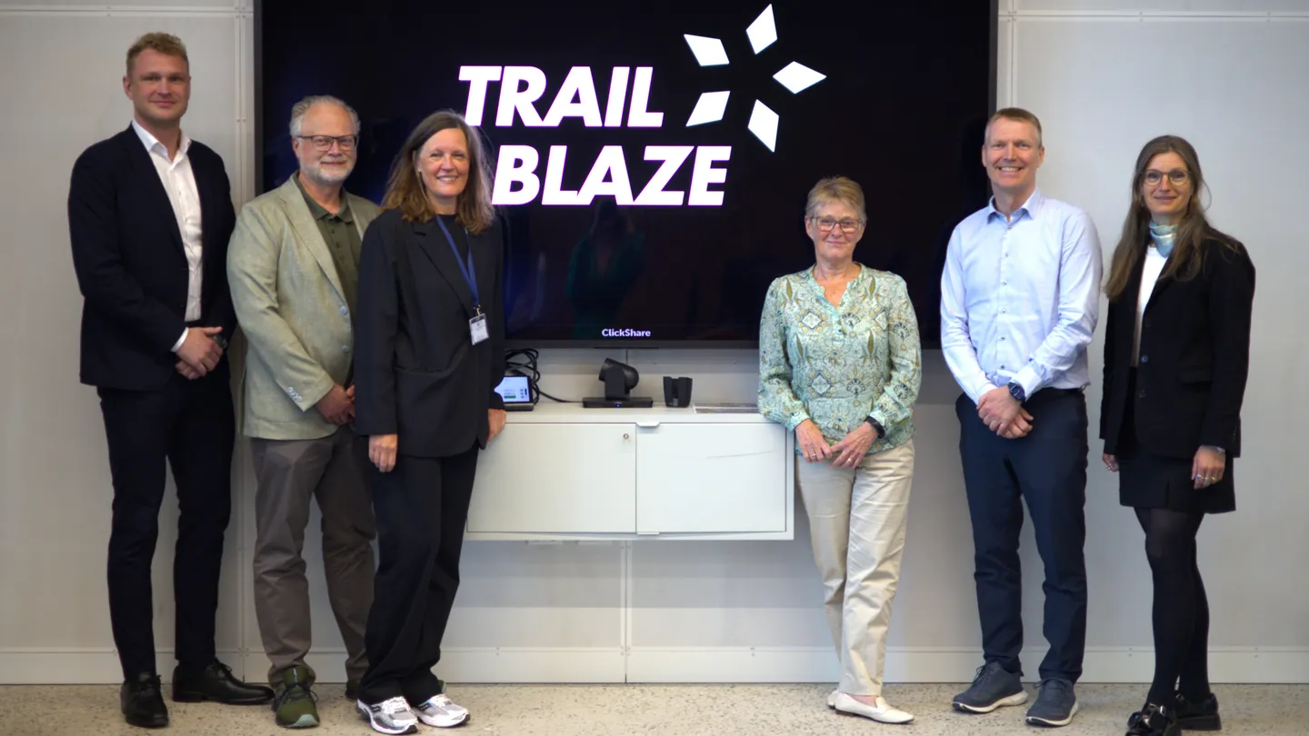 The advisory board gathered in front of a screen with the TrailBlaze logo