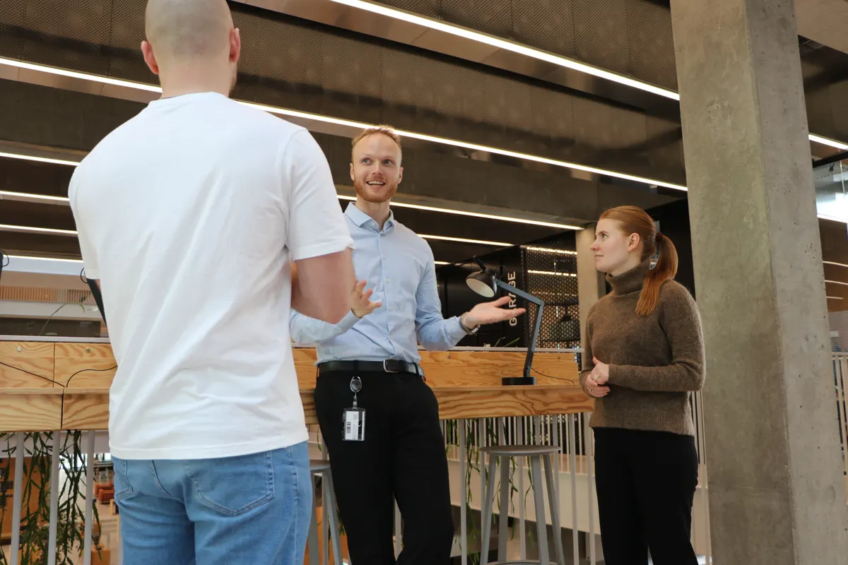 Three people talking in a bright office setting